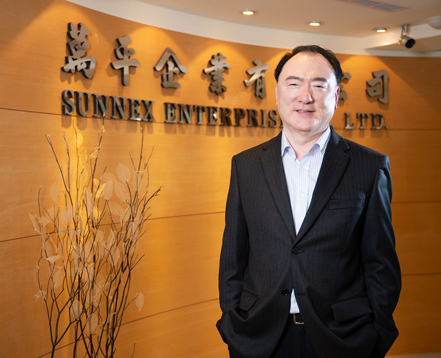 創辦人張高雄先生於萬平企業形象牆前留影